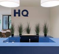 Neobmedzený prístup do coworkingu v oblasti HQ Seberiniho - Recepcia s modrým pultom, rastlinami a počítačom v Kanceláriách.