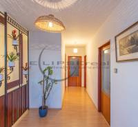 NA PREDAJ priestranný 4-izbový rodinný dom v Plaveckom Štvrtku - Chodba v rodinnom dome s podlahou s dreveným dekorom, kvetinami a osvetlením.