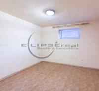 NA PREDAJ priestranný 4-izbový rodinný dom v Plaveckom Štvrtku - Prázdna izba v rodinnom dome s podlahou s dreveným dekorom a malým oknom.