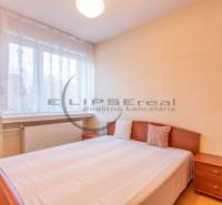 NA PREDAJ priestranný 4-izbový rodinný dom v Plaveckom Štvrtku - Spálňa v rodinnom dome s posteľou, nočným stolíkom a podlahou s dreveným dekorom.