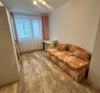 Prenajom 3 izb. bytu na Vajanskeho v NZ - Izba v 3-izbovom byte s podlahou s dreveným dekorom a rozkladacou pohovkou.