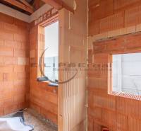 NA PREDAJ NOVOSTAVBA moderný 4-izbový rodinný dom v Malých Levároch - Nedokončený interiér rodinného domu s tehlovými stenami a stavbou bez podláh.