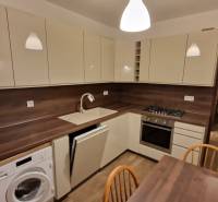 Na prenájom zariadený 3 izbový byt s balkónom Galanta- Mierová - Kuchyňa v 3-izbovom byte s bielymi skrinkami a podlahou s dreveným dekorom.