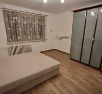 Na prenájom zariadený 3 izbový byt s balkónom Galanta- Mierová - Spálňa v 3-izbovom byte s posteľou, skriňou a podlahou s dreveným dekorom.