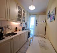 Pekný 2 izbový byt na Jadrovej ul. - Kuchyňa v 2-izbovom byte s bielym nábytkom a jedálenským stolom.