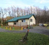 Zabehnutý multifunkčný rekreačný areál (kemp) Kuchyňa na predaj - Chata obklopená zeleňou a stromami na Rekreačných pozemkoch v Kuchyni.