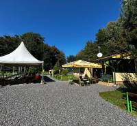 Zabehnutý multifunkčný rekreačný areál (kemp) Kuchyňa na predaj - Rekreačné pozemky v Kuchyni s terasou, stanom na posedenie a zeleným okolím.