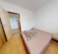 REZERVOVANÉ/ 3- izbový byt blízko centra mesta, Vrbové - Spálňa s podlahou s dreveným dekorom v 3-izbovom byte, obsahujúca posteľ a nočný stolík.