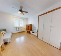 REZERVOVANÉ/ 3- izbový byt blízko centra mesta, Vrbové - V 3-izbovom byte nábytok na podlahe s dreveným dekorom, stropný ventilátor, biele steny.