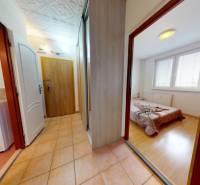 REZERVOVANÉ/ 3- izbový byt blízko centra mesta, Vrbové - Chodba v 3-izbovom byte s pračkou, posteľou a podlahou s dreveným dekorom.