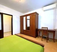 Útulný byt s loggiou a klimatizáciou, Rovniankova.Províziu neplatíte - Spálňa s podlahou s dreveným dekorom, skriňou, pracovným stolom a klimatizáciou v 3-izbovom byte.