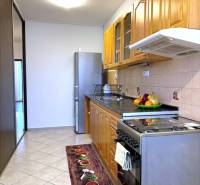 Útulný byt s loggiou a klimatizáciou, Rovniankova.Províziu neplatíte - Kuchyňa v 3-izbovom byte s dlažbou, drevenými skrinkami, chladničkou a sporákom.