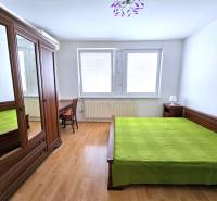 Útulný byt s loggiou a klimatizáciou, Rovniankova.Províziu neplatíte - Spálňa v 3-izbovom byte, drevený nábytok, zelená posteľná bielizeň, podlaha s dreveným dekorom.