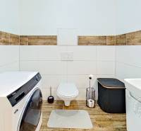 Mezonetový 3-izb. byt, Stará Ľubovňa, Popradská ulica - Kúpeľňa v 3-izbovom byte so závesným WC, práčkou a obkladom s dreveným dekorom.