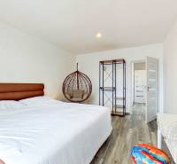 Mezonetový 3-izb. byt, Stará Ľubovňa, Popradská ulica - Spálňa s veľkou posteľou a hojdačkou v 3-izbovom byte, podlaha s dreveným dekorom.