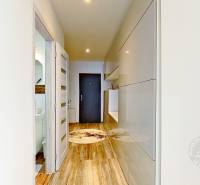 Mezonetový 3-izb. byt, Stará Ľubovňa, Popradská ulica - Předsieň 3-izbového bytu s bielymi stenami, podlahou s dreveným dekorom a vstavanými skriňami.