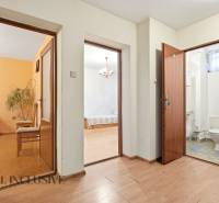 Na predaj 4-izb. rodinný dom s garážou, Okoč - Chodba s dverami do izieb a kúpeľne, podlaha s dreveným dekorom v rodinnom dome.