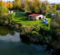 KH-1018, PREDAJ Pozemok pri jazere 887 m², garáž, altánok - Pokojná chatka pri rieke obklopená zeleňou a stromami v okolí Čane, výstavba domov.