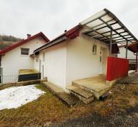 EXKLUZÍVNE / RODINNÝ DOM NA PREDAJ V OBCI SÚĽOV - Rodinný dom v Súľove-Hradnej s červenou strechou, zasneženou záhradou a prístreškom.