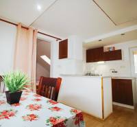 EXKLUZÍVNE / RODINNÝ DOM NA PREDAJ V OBCI SÚĽOV - Jedálenský kút s kvetinovým obrusom, kuchynským kútom a podlahou s dreveným dekorom.