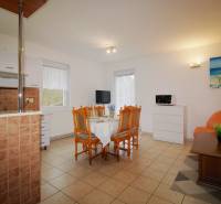 EXKLUZÍVNE / RODINNÝ DOM NA PREDAJ V OBCI SÚĽOV - Obývacia izba v Rodinnom dome s jedálenským stolom, oranžovou sedačkou a dekoratívnym obrazom.