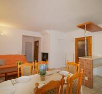 EXKLUZÍVNE / RODINNÝ DOM NA PREDAJ V OBCI SÚĽOV - Jedáleň v rodinnom dome so stolom, oranžovou pohovkou a dekoratívnymi vankúšmi.