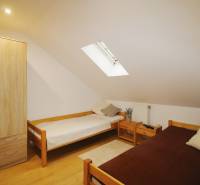 EXKLUZÍVNE / RODINNÝ DOM NA PREDAJ V OBCI SÚĽOV - Podkrovná izba v rodinnom dome s dvoma posteľami, drevenou skriňou a strešným oknom.