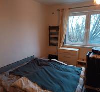 Na predaj rodinný dom Orovnica - Spálňa v rodinnom dome s posteľou, komodou a stromami viditeľnými z okna.