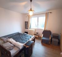 Na predaj rodinný dom Orovnica - Spálňa v rodinnom dome s posteľou, kreslom a podlahou s dreveným dekorom.