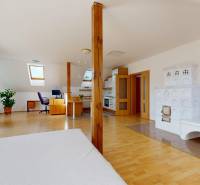 RIVERS | Viacgeneračný zrekonštruovaný rodinný dom v Ivanke pri Dunaji - Podkrovný interiér rodinného domu s kachľovou pecou, pracovným kútom a podlahou s dreveným dekorom.