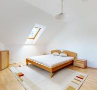 RIVERS | Viacgeneračný zrekonštruovaný rodinný dom v Ivanke pri Dunaji - Svetlá spálňa v rodinnom dome s podlahou s dreveným dekorom a strešným oknom.