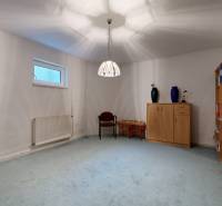 RIVERS | Viacgeneračný zrekonštruovaný rodinný dom v Ivanke pri Dunaji - Izba v rodinnom dome s kobercovou podlahou, knihovníčkou a jednoduchým nábytkom.