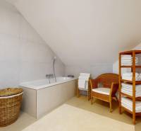 RIVERS | Viacgeneračný zrekonštruovaný rodinný dom v Ivanke pri Dunaji - Kúpeľňa v rodinnom dome s vaňou, prúteným kreslom a poličkou s uterákmi.