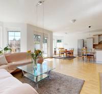 RIVERS | Viacgeneračný zrekonštruovaný rodinný dom v Ivanke pri Dunaji - Obývačka s kuchyňou v rodinnom dome s podlahou s dreveným dekorom a presklenými dverami.