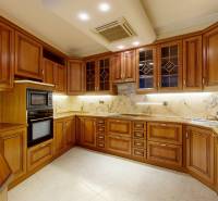 Veľkometrážny byt na Slavíne s výhľadom na mesto - Na obrázku je kuchyňa so vstavanými drevenými skrinkami a mramorovou pracovnou doskou.