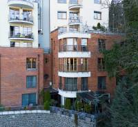 Veľkometrážny byt na Slavíne s výhľadom na mesto - Pohľad na viacpodlažnú budovu nachádzajúcu sa na ulici Havlíčkova, obklopenú zeleňou.