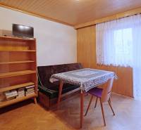 Nová ponuka - Rodinný dom v CENTRE MESTA Rajecké Teplice - Izba v rodinnom dome s podlahou s dreveným dekorom, stolom a policou.