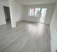 Na predaj 2 izb. byt s balkónom blízko centra, Chorvátsky Grob - Obývacia miestnosť v 2-izbovom byte s podlahou s dreveným dekorom a veľkými oknami.