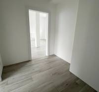 Na predaj 2 izb. byt s balkónom blízko centra, Chorvátsky Grob - Priestor v 2-izbovom byte s bielymi stenami a podlahou s dreveným dekorom.