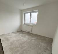 Na predaj 3 izb. byt s balkónom blízko centra, Chorvátsky Grob - Nezariadená izba so sivo-betónovou podlahou a bielymi stenami v 3-izbovom byte.