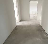 Na predaj 3 izb. byt s balkónom blízko centra, Chorvátsky Grob - Chodba v 3-izbovom byte s betónovou podlahou a bielymi stenami.