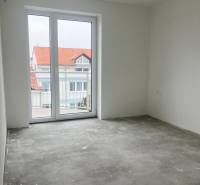 Na predaj 3 izb. s 2 balkónmi a panoramatickým výhľadom - Prázdna miestnosť s sivou podlahou a veľkým oknom v 3-izbovom byte.