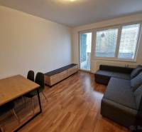 Na  prenájom 2-izb. byt, Bratislava, Ružinov, Vlčie hrdlo ulica - Obývačka s rohovou sedačkou, jedálenským stolom a podlahou s dreveným dekorom v 2-izbovom byte.