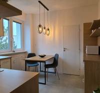 PRENÁJOM - Priestranný 3 izbový byt - Nitra, Centrum - Kuchyňa v 3-izbovom byte s podlahou s dreveným dekorom a závesnými svietidlami.