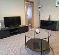 PRENÁJOM - Priestranný 3 izbový byt - Nitra, Centrum - Obývačka v 3-izbovom byte s TV, guľatým stolom a dekoratívnymi prvkami.