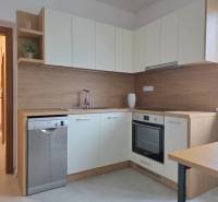 PRENÁJOM - Priestranný 3 izbový byt - Nitra, Centrum - Kuchyňa v 3-izbovom byte s bielymi skrinkami a podlahou s dreveným dekorom.