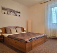 PRENÁJOM - Priestranný 3 izbový byt - Nitra, Centrum - Spálňa v 3-izbovom byte s posteľou, obrazom, nočnými lampami a závesmi.