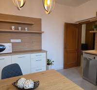 PRENÁJOM - Priestranný 3 izbový byt - Nitra, Centrum - Kuchyňa so stolom a stoličkou v 3-izbovom byte, s dreveným dekorom a mikrovlnkou.