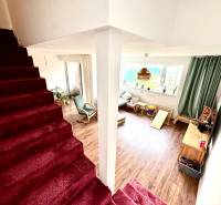 Moderný radový rodinný dom v Novej Dedinke, projekt “Lastovičky” - Interiér rodinného domu so schodiskom a obývačkou s podlahou s dreveným dekorom.