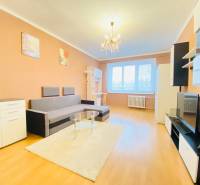 NA PRENÁJOM 2-IZBOVÝ BYT, NÁRODNÁ TRIEDA - Obývacia izba v 2-izbovom byte s podlahou s dreveným dekorom, sedačka, nábytok, luster.